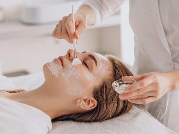 mujer en spa se realiza tratamientos faciales y mascarillas