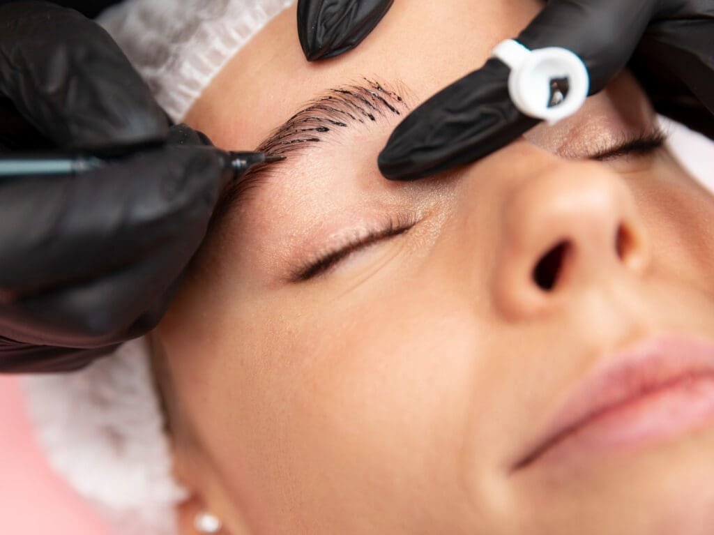 Procedimiento de micropigmentación de cejas sobre una mujer joven