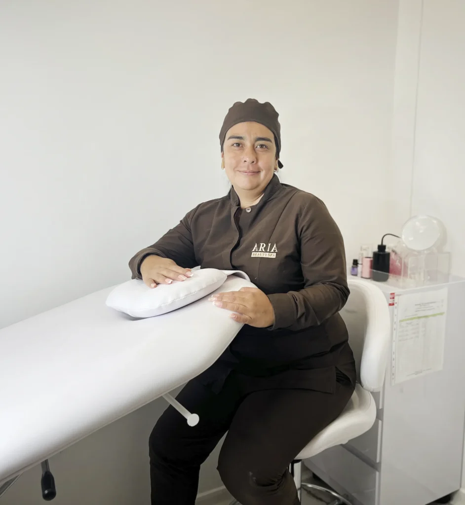 Manicurista con uniforme café en fondo blanco